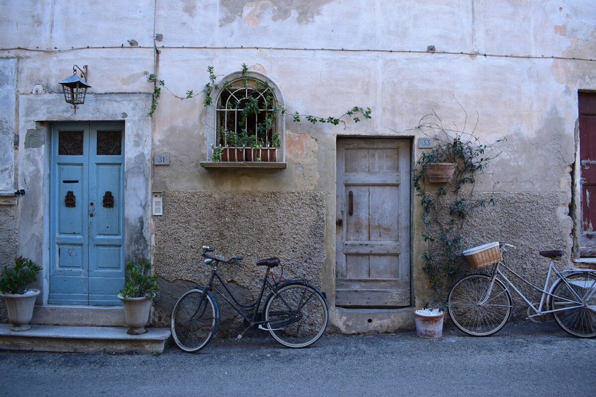 Bicycle hanging from a wall mount in a narrow apartment hallway