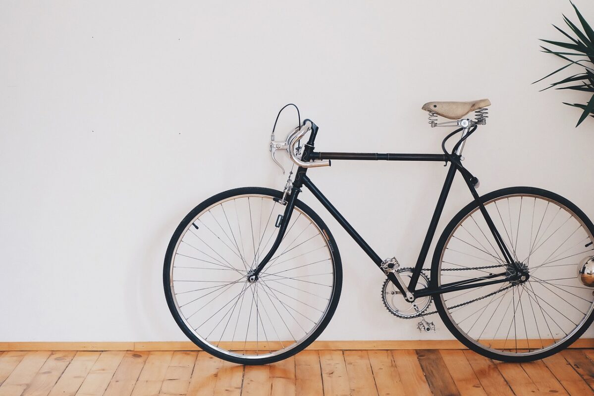 Two bicycles stored against a wall in a narrow corridor