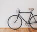 Two bicycles stored against a wall in a narrow corridor