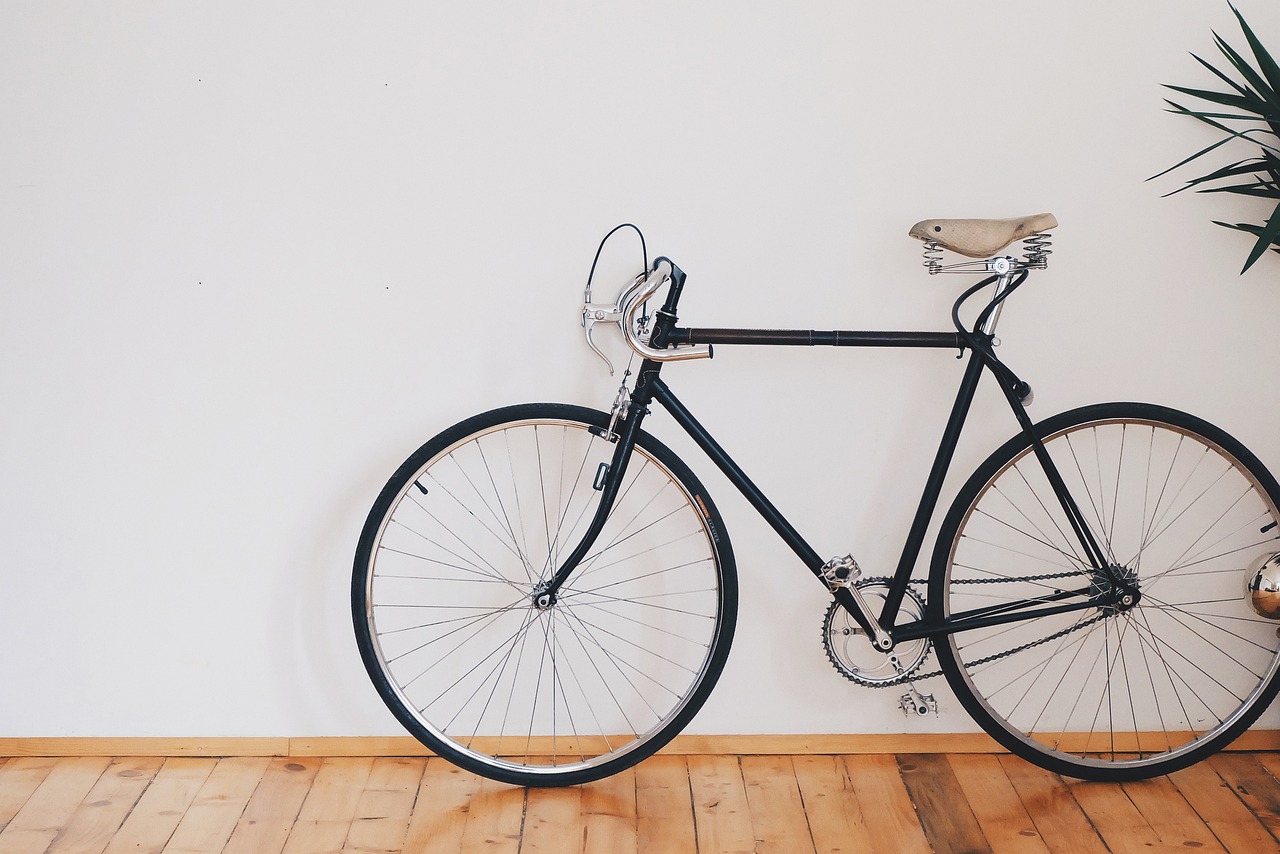 Two bicycles stored against a wall in a narrow corridor